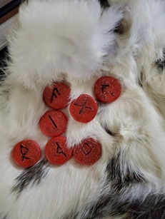 Seven red carved runes on a piece of white fur