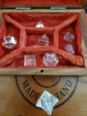 Different shaped crystals in a red fabric lined box  